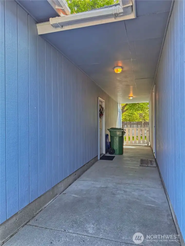 The covered breezeway seamlessly connects to the home providing a weather-protected transition space for every season.