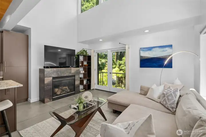 Warm and welcoming living area featuring soaring ceilings, a fireplace, and tranquil garden views. Warm and welcoming living area featuring soaring ceilings, a fireplace, and tranquil garden views.