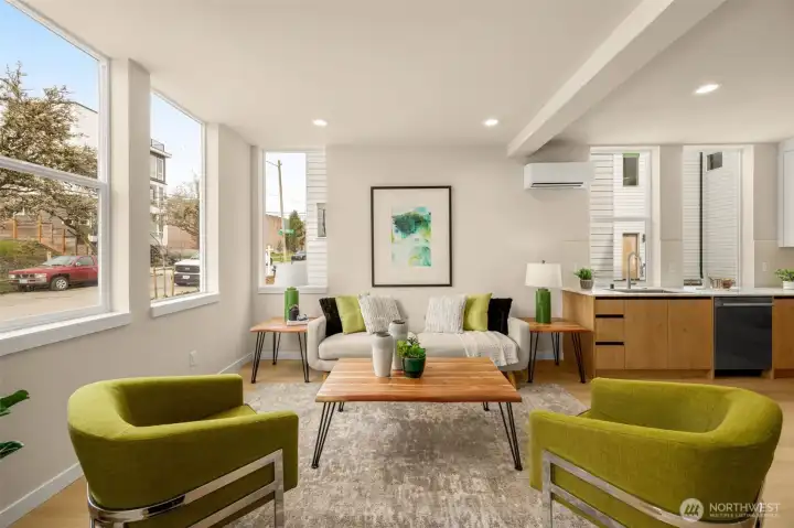 Warm and welcoming living room showcasing large windows and modern design elements. (photos are of model home, same community similar finishes)