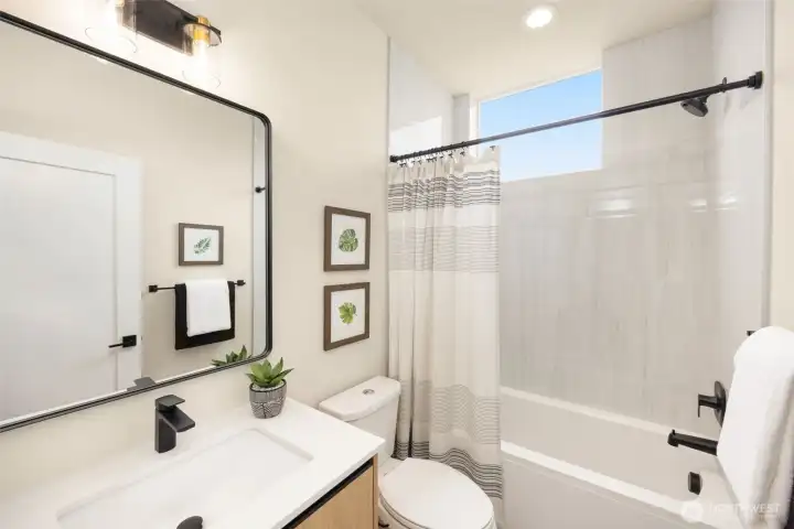 Pristine bathroom boasting clean lines, modern fixtures, and a glass-enclosed shower. (photos are of model home, same community similar finishes)