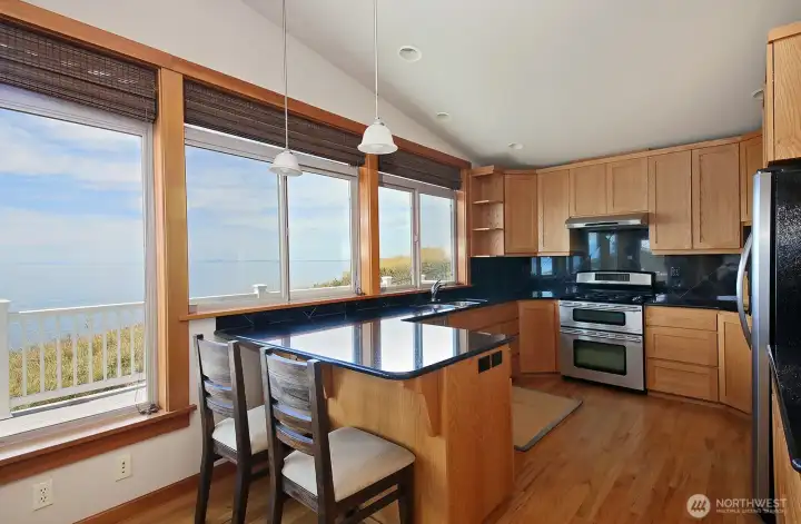 Oak floors and cabinets in the kitchen with granite countertops and backsplash. Stainless steel appliances include a double oven/propane stove. Oak floors and cabinets in the kitchen with granite countertops and backsplash. Stainless steel appliances include a double oven/propane stove.