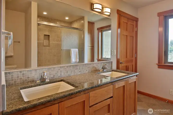 Here is the primary bathroom with double sinks, granite countertops, ceramic tile and radiant floor heat. Here is the primary bathroom with double sinks, granite countertops, ceramic tile and radiant floor heat.