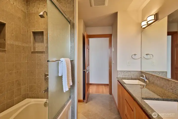 This bathroom is accessed by both the primary bedroom and the hall. This bathroom is accessed by both the primary bedroom and the hall.