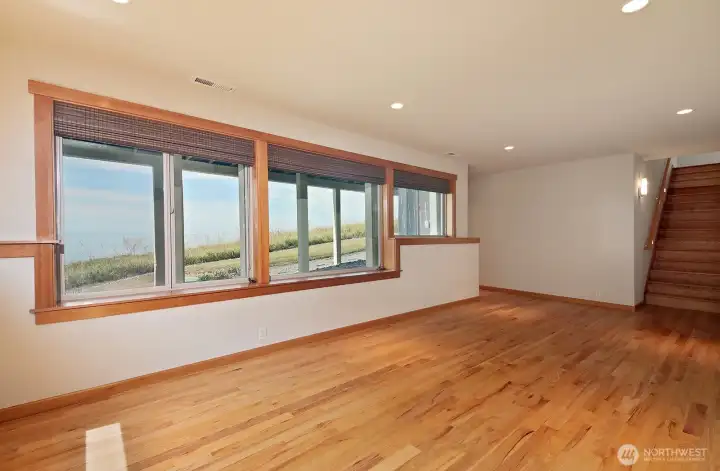 We are now on the lower level. The views continue in this family room.There is a nook to the right of the stairs that makes a perfect spot for a desk. We are now on the lower level. The views continue in this family room.There is a nook to the right of the stairs that makes a perfect spot for a desk.