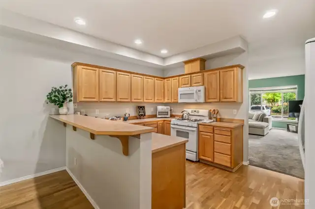 Kitchen opens to family room and features eating bar as well as lots of cabinets.