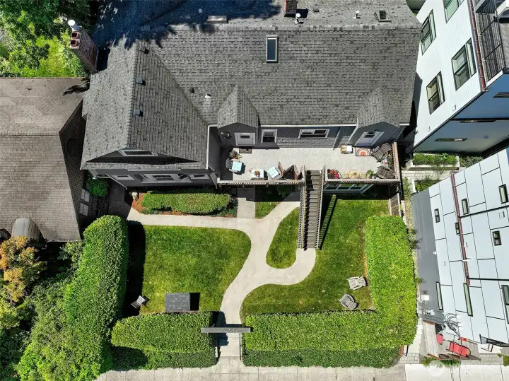 This overhead view of Laurel Gate reveals a rare combination in Capitol Hill multifamily: a flat, 7,200 SF street-to-alley parcel with mature landscaping, formal walkways, and seven dedicated off-street parking spaces tucked discreetly in back. The colonial revival building—surrounded by a privacy hedge—sits within LR3(M) zoning, offering income today and the possibility of added density tomorrow. A quintessential Capitol Hill garden courtyard, rooted in Seattle history.