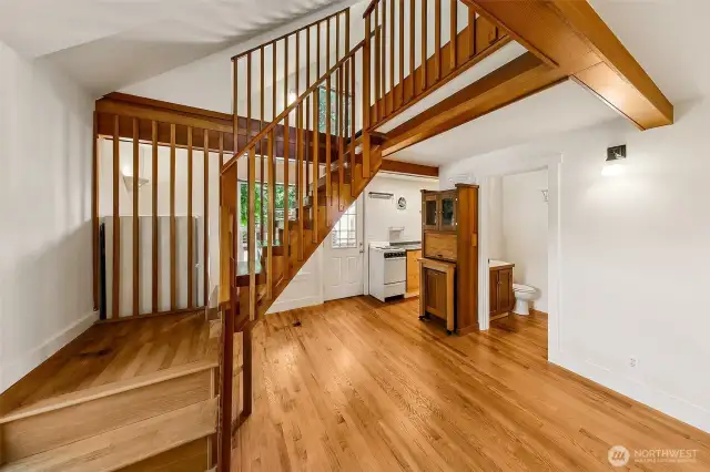 Apartment #7 - On the second floor with a small deck area, apartment 7 features oak floors, small kitchen, full bathroom and repurposed storage hutch from an area houseboat with built in garbage container, chopping block, and storage cabinet with glass doors. Follow the timber frame stairs up to the spacious sleeping loft.