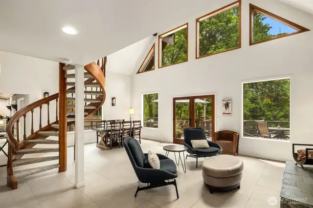 Dramatic great room showcases a soaring ceiling and wall of windows allowing the natural light to spill inside.