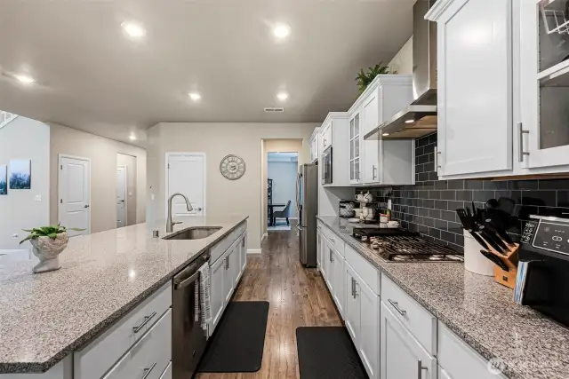 Gourmet kitchen w/stainless steel appliances, gas cooktop, full height tile backsplash, large walk in pantry, glass front cabinets & granite counter tops.