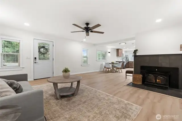 New LVP flooring, recessed lighting, tiled fireplace, and beautiful window trim