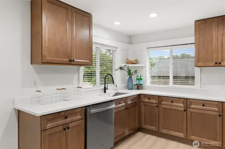 The color scheme with the white quartz countertops matched with light majestic wood cabinets is spectacular