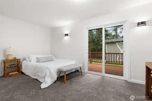 The primary suite features a sliding glass door to the large cedar deck