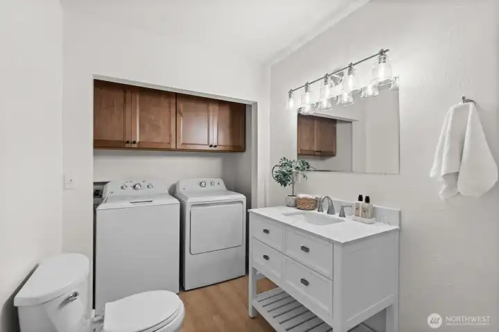 The 3/4 bath with a brand new washer and dryer set and cabinets above