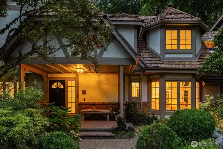 Charming front entry framed by mature landscaping and Tudor details
