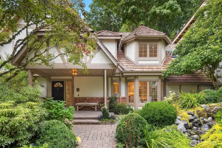 Garden walkways lead to a serene waterfall and picturesque front approach
