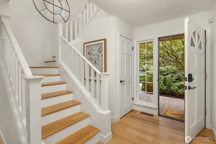 Bright entryway with hardwood floors and an elegant staircase