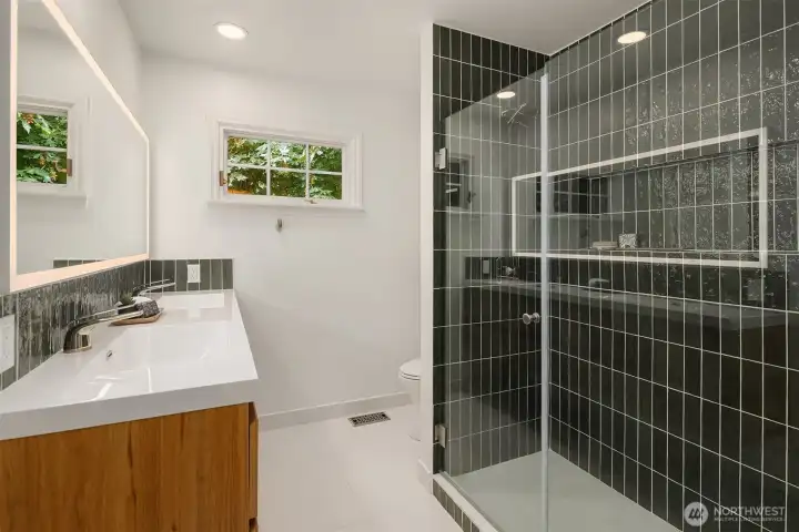 Modern bath with sleek tile shower and updated fixtures