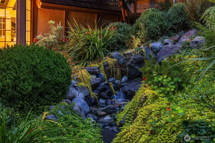 Waterfall feature and professional landscaping add tranquility and charm.