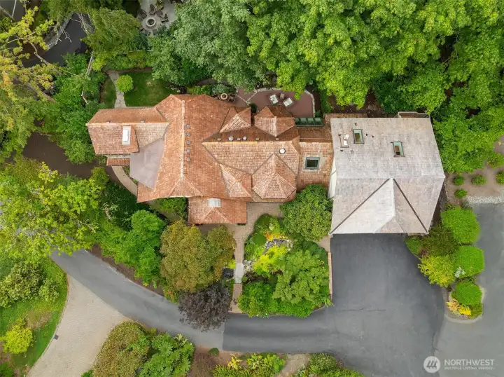 Aerial view showcases the Tudor architecture nestled among mature trees