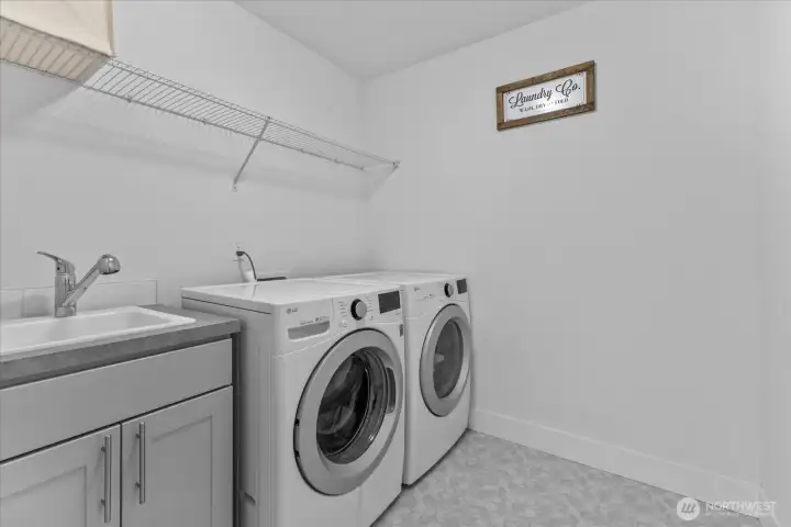 Dedicated upstairs laundry room with washer, dryer, cabinetry, and folding space—adding everyday convenience to this Stonebrook residence.