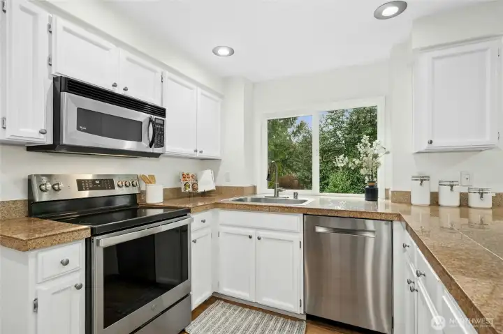 White painted cabinetry, granite counter tops and stainless steel appliances.