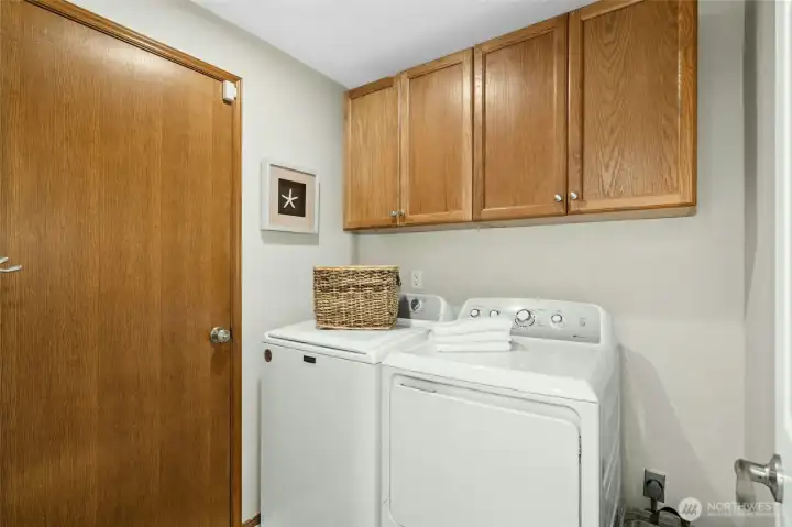 Utility room with cabinets and a door leading out to the garage.