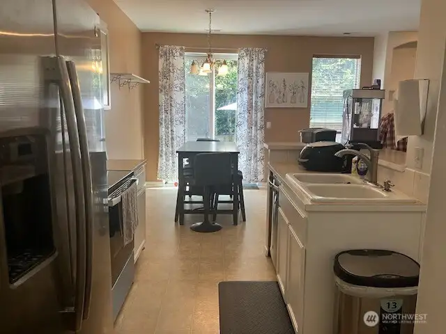 Kitchen with stainless steel appliances flows through to dining area, then slider to fenced back yard with patio for entertaining!