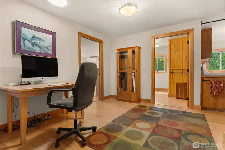 Office area leading to bedrooms, bath, mudroom and garage .