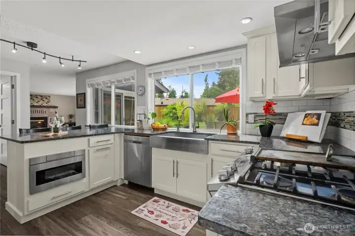 Lovely bright open space with ample prep space, abundant storage, Gas range, Farm sink and bar top seating