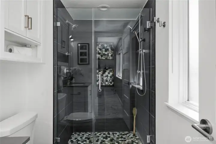 Remodeled primary bath finished in slate tiles and river rock finishes