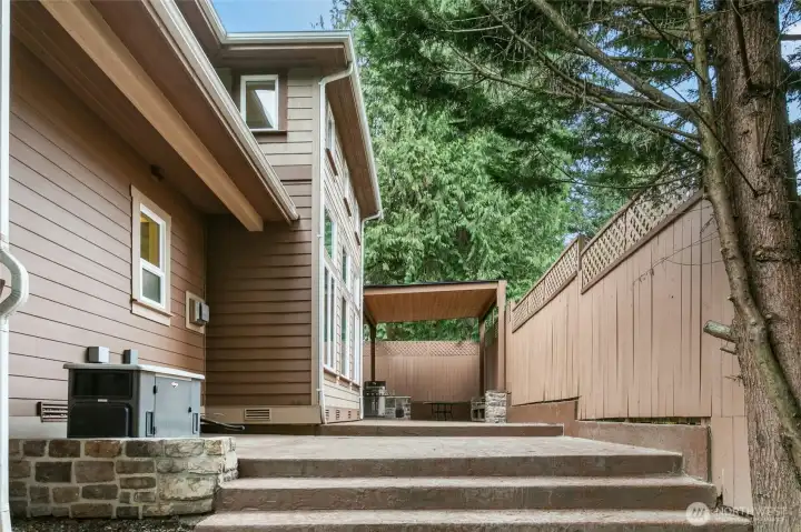 Spacious backyard patio with built-in gas grill and custom bench seating—perfect for entertaining.