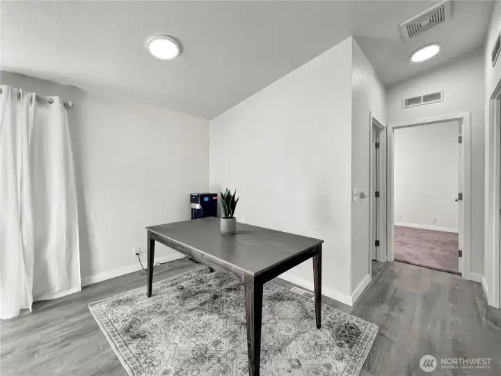Designated dining area featuring vaulted ceilings that flows seamlessly into two additional bedrooms, a full bathroom, and the kitchen. Designated dining area featuring vaulted ceilings that flows seamlessly into two additional bedrooms, a full bathroom, and the kitchen.