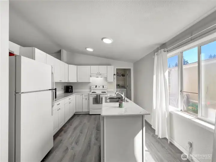Spacious kitchen featuring abundant cabinet and countertop prep space, newer appliances, and convenient direct access to the utility room. Spacious kitchen featuring abundant cabinet and countertop prep space, newer appliances, and convenient direct access to the utility room.