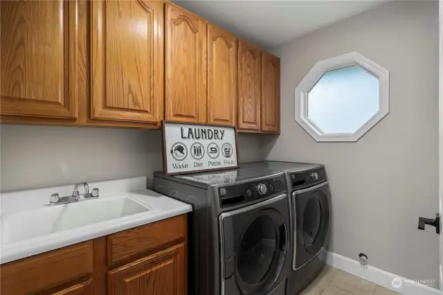 The spacious laundry room features a convenient sink and ample cabinet space, offering its functionality