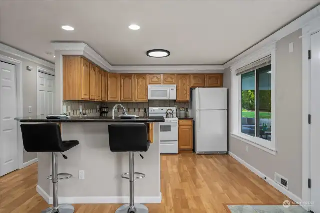 The ADU kitchen is a delightful space, seamlessly blending with the living area and offering a picturesque view of the patio and lake beyond. The open layout enhances the sense of space and connection, making it a perfect spot for relaxing or entertaining.