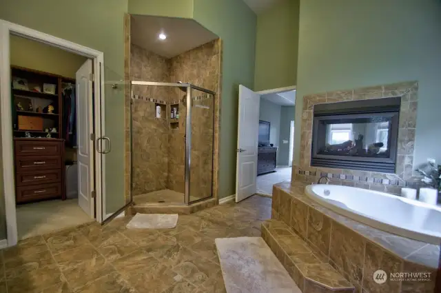 Heated Tile flooring and towel racks. Oversized shower and live in closet. view into the bedroom