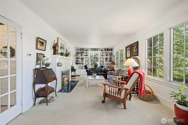 French doors to the left open up to the perfect conversation room to gather around the warm fireplace.