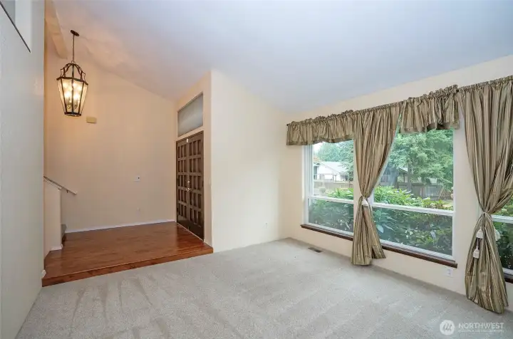 As you enter the home, you are greeted by the main-floor living area, featuring three large picture windows and newer carpeting.