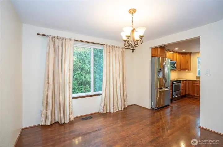 View of the kitchen from the dining area, highlighted by a picture-perfect window overlooking the backyard.