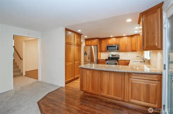 From the family room, you can see the expansive kitchen with an eating bar, and the dining area is just around the corner.