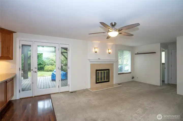 Lower-level family room featuring a second fireplace and newer carpeting, complemented by a ceiling fan for added comfort.
