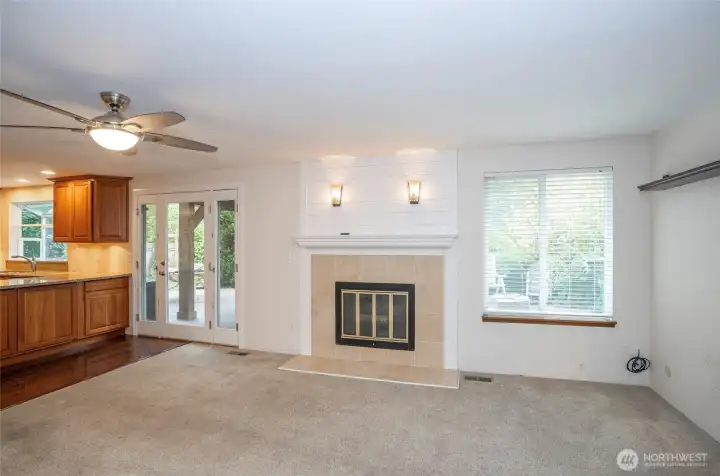 Family room featuring a large side window that fills the space with natural light, complemented by stunning designer sconce lighting above the fireplace.