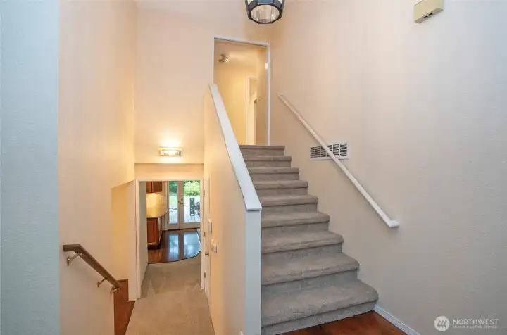 Main entry showcasing stylish staircases that lead to both the upper and lower levels.