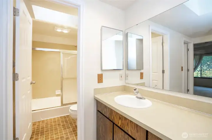 Another perspective of the primary bathroom, featuring a private doorway to the shower and toilet area for added privacy.