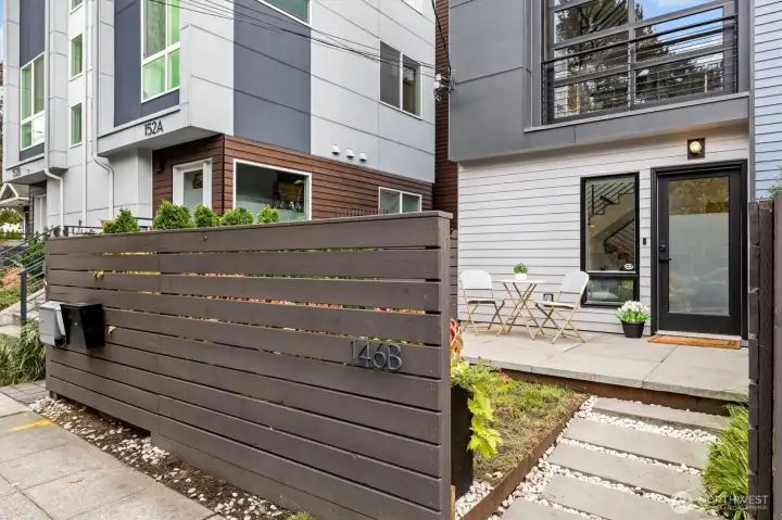 Gorgeous, fenced entry with a garden area to the right, and a paved patio great for enjoying the outdoors!