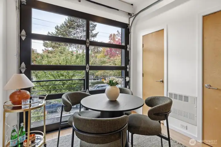Spacious dining area with a super cool roll up door! To the right is another pantry, and a powder bath!