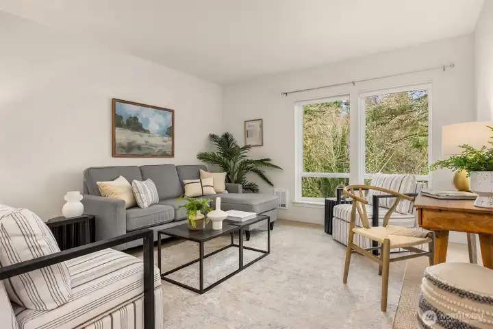 Light-filled living space overlooking lush greenery, creating a peaceful and private top-floor setting.