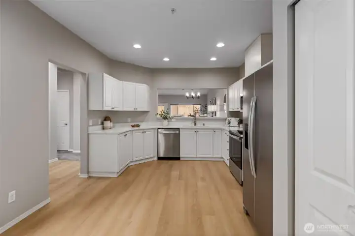 Renovated kitchen with brand new quartz countertops and appliances. The kitchen has space for a small table.