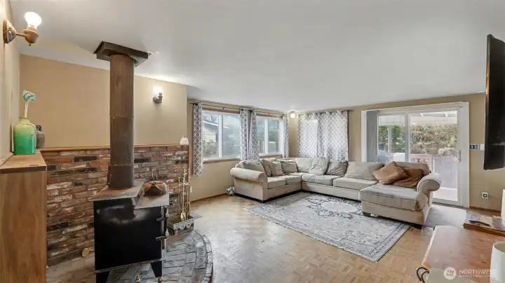 Spacious living room featuring a cozy freestanding wood stove on brick hearth.