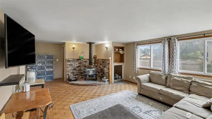 Spacious living room featuring a cozy freestanding wood stove on a beautiful brick hearth.